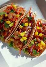 Overhead view of 3 shrimp tacos with bacon and pineapple