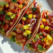 Overhead view of 3 shrimp tacos with bacon and pineapple