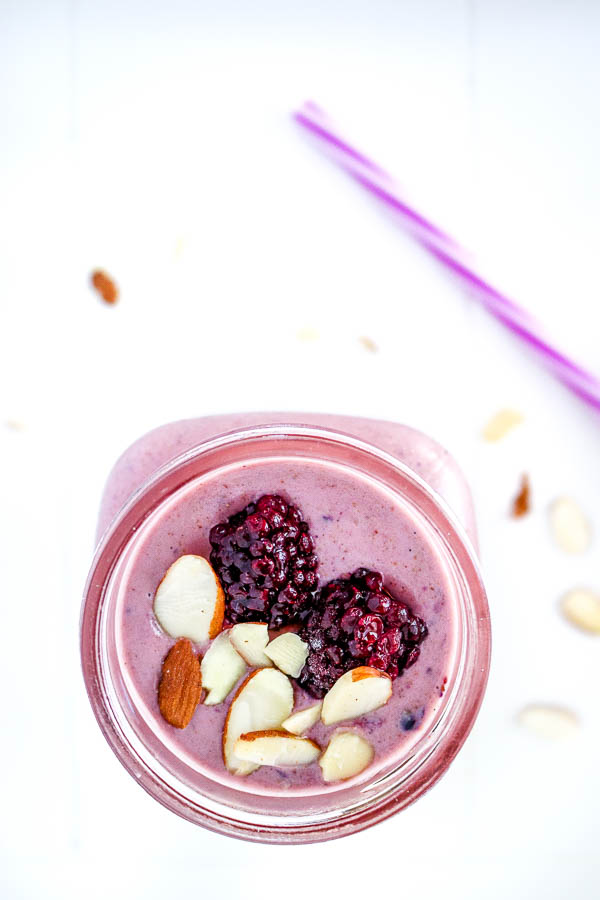 Overhead view of almond berry smoothies with blackberry and sliced almond garnishes