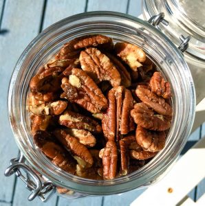 overhead view of candied pecans in glass jar