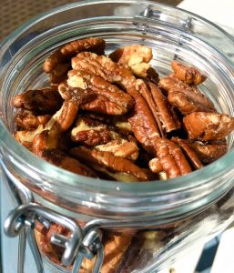 closeup view of candied pecans in glass jar