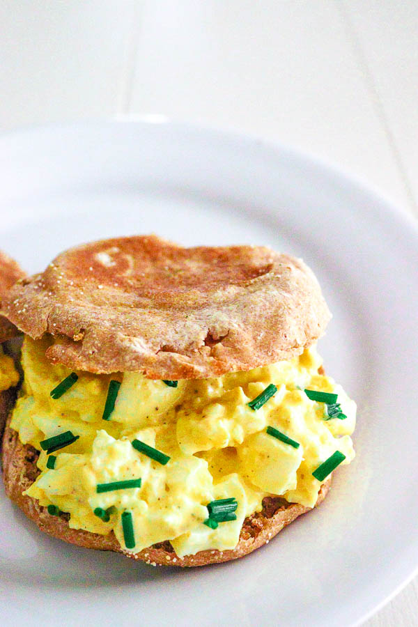 single egg salad sandwich with chives on an english muffin