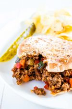 sloppy joe sandwich on a plate with bite taken