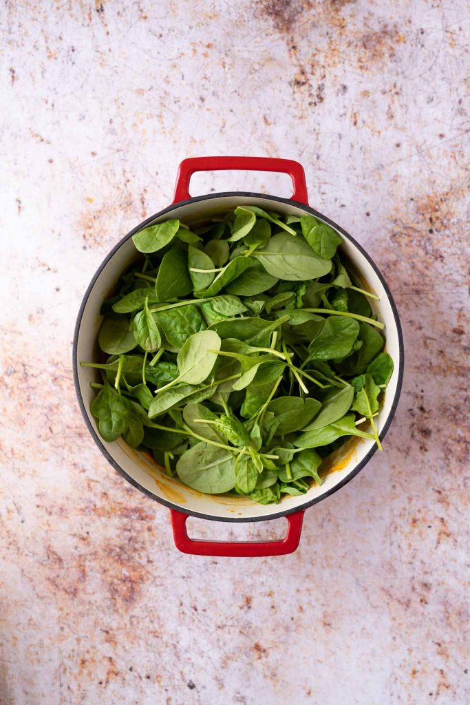 Curry topped with spinach in pot