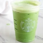 Matcha green tea latte in Starbucks cup with white background.