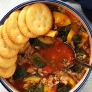 sausage kale soup in bowl, half lined with ritz crackers.