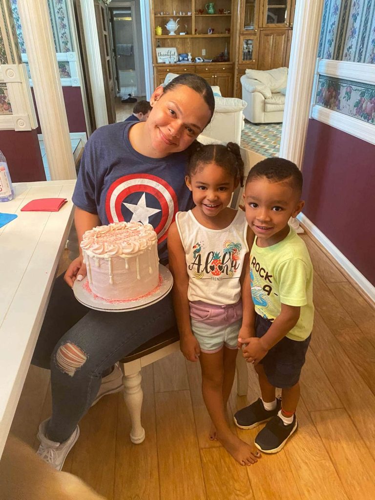 Traci and her kids at table with birthday cake.